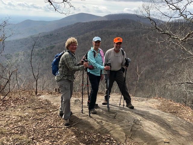Three hikers mountain ridge trekking poles