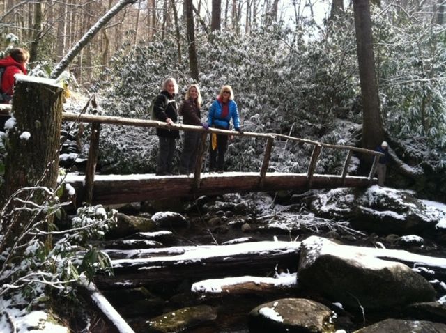 Hikers group wooden bridge winter forest