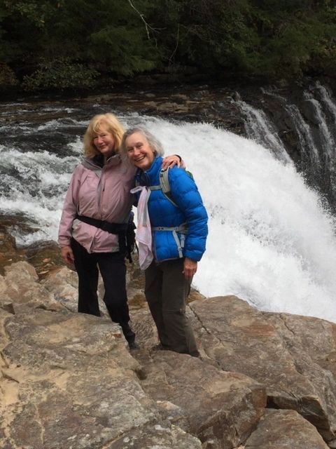 Two women hikers waterfall smiling